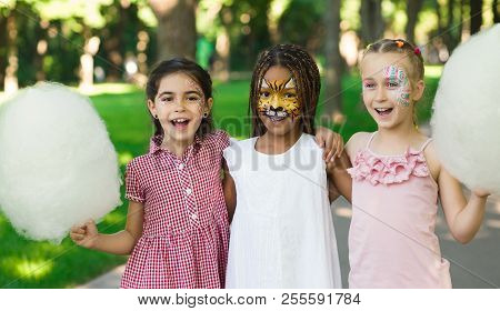 Happy Weekend In Park. Multiethnic Girls Friends Enjoying Day In Amusement Park, Embracing And Havin