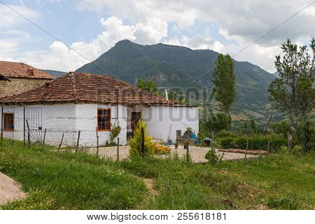 Trebinje, Albania- 27 June 2014: Old Building In Village Trebinje. Mountain In The Background.