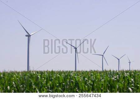 Windmills Power Plant In Rural Landscape. Wind Turbine Farm For Electric Power Production. Windmills