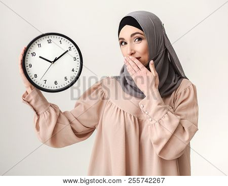 Time To Hurry. Saudi Woman Holding Clock At White Baclground