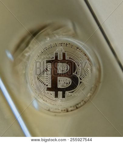 Bitcoin Metal Coin Through A Glass Prism. Abstract View On Uncertainty Of Crypto Currency