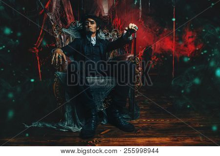 Halloween. Mysterious gloomy man in a black tailcoat in an old abandoned castle. The Dark Lord. Vampire man. 