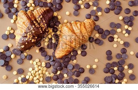 Classic Croissants And Caramelized And Dark Chocolate Couverture On Brown Background. Sweet Food Des