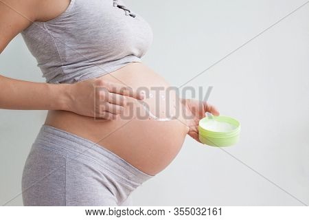 A Pregnant Woman Applies Stretch Marks Cream To Her Stomach. Stretch Marks. Striae. Moisturize The S