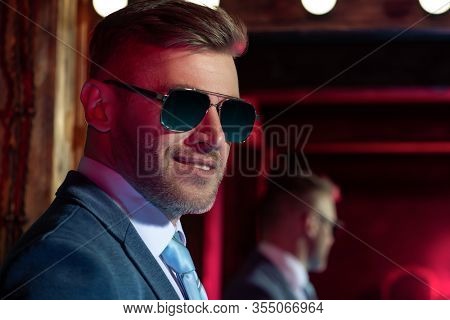 A portrait of a brutal handsome man in sunglasses. Men's beauty, fashion. Optics for men.