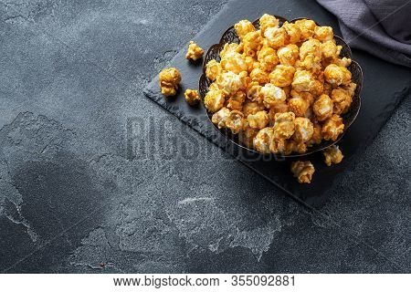 Popcorn In Caramel Glaze In A Plate On A Dark Concrete Table. Copy Space.