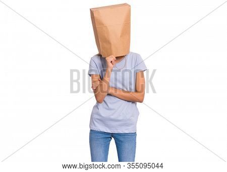 Pensive teen girl with paper bag over head. Thoughtful teenager cover head with bag holding hand near face isolated on white background. Child pulling paper bag over head.
