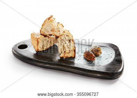 Burnt ciabatta with two kinds of butter. Aromatic fresh bread on wooden cutting board. Delicious rustic meal and cooking utensil. Traditional italian dish. Food presentation, pastry on white surface
