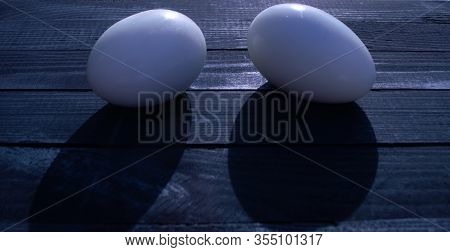 Two Eggs Lie On A Wooden Table