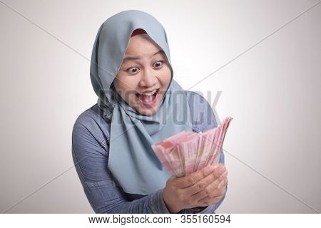 Indonesian Muslim Woman Holding Rupiah Money