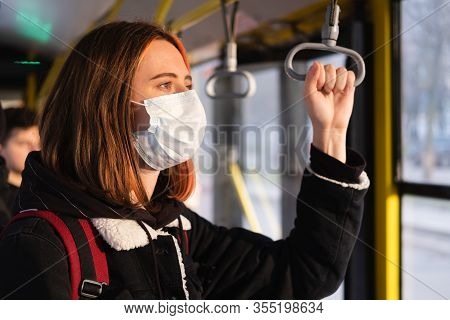 Woman In A Protective Mask On The Train Or On The Bus. Coronavirus, Covid-19 Spread Prevention Conce