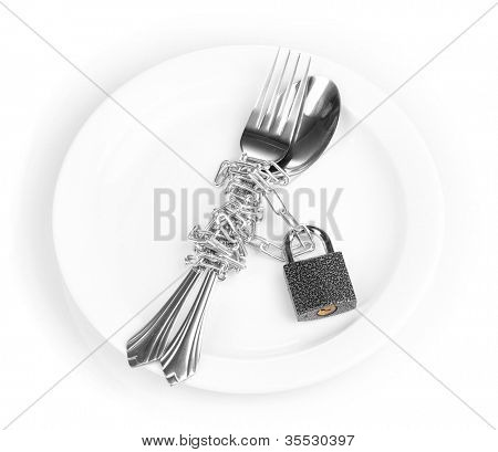 Forchetta e cucchiaio con catena e lucchetto sul piatto isolata on white