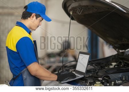 Car Repair Technicians Use Laptop Computers To Measure Engine Values For Analysis In Car Cervice Cen