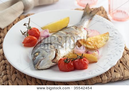 감자, 양파, 체리 토마토와 구운된 도미