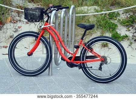 Red Bicycle Parked By A Sand Dune At The Entrance To Southpointe Park Beach On Miami Beach,florida