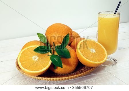 A Glass Of Fresh Orange Juice And Orange Fruits On A Wooden Table. Healthy Food