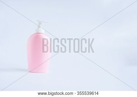 Pink Plastic Bottle With White Pump For Liquid Soap  Or Bodycream Care, Cosmetique On White Blue Bac