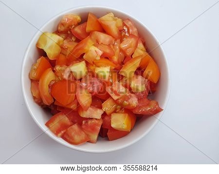Top View Of Tomatoes Sliced In White Bowl Isolated On White Background (solanum Lycopersicum Var. Ce