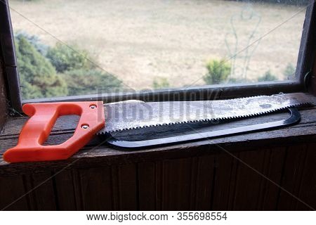 A Handsaw On A Wooden Background. Tools