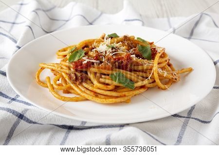 Homemade Bucatini All Amatriciana Pasta In A White Plate On Cloth, Side View. Close-up.
