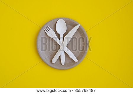 Eco- Friendly Tableware For Food And Wooden Eco-knife, Fork, Spoon On A Yellow Background With A Cop