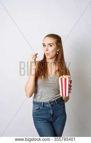 Beautiful Blonde Girl Eat Popcorn And Watch Comedia Movie Isolated On White Background. Copy Space, 
