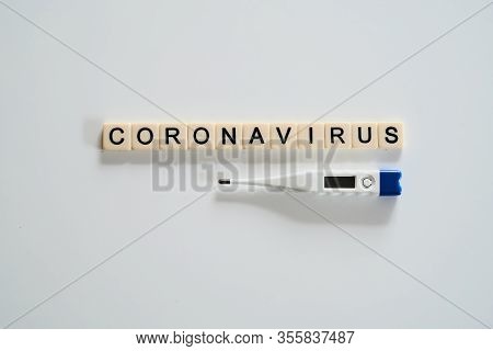 Coronavirus Spelt With Tiles And Thermometer On White Background