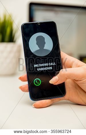 Unknown Caller. A Man Holds A Phone In His Hand And Thinks To End The Call. Incoming From An Unknown