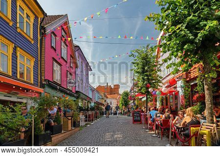 Stavanger, Norway - August 19, 2021: Tourists On Historical Street In Stavanger Old Town With Multic