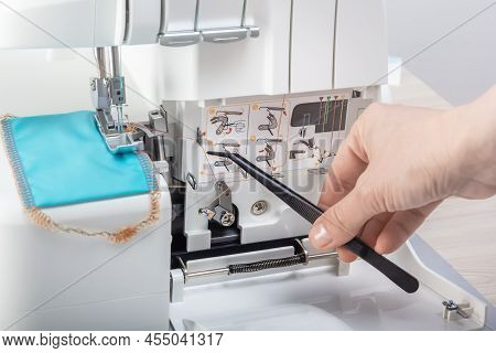 Hand With Tweezers Puts The Thread In The Mechanism Of The Sewing Machine