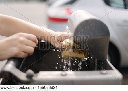 Female Wash Rug In Water. Close-up Womans Hand In Front Of Car On Self Servise Car Wash. Squeez Rug