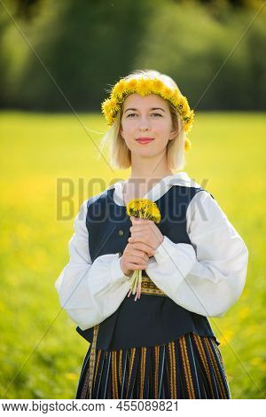 Young Woman In National Clothes Wearing Yellow Dandelion Wreath In Spring Field. Ligo