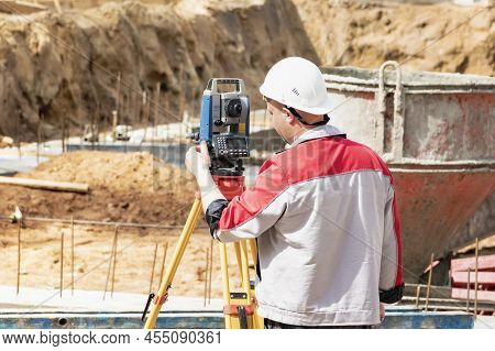 Construction Of A Residential Area. Geodetic Stakeout. Surveyor At A Large Construction Site. A Man 