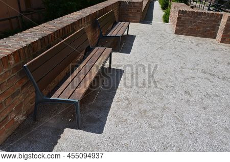 Stairs And Railings Of Exposed Brick Smooth Surface. Metal Railings And Benches In The Corners Of Th