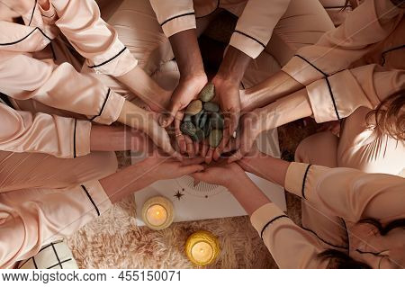 Hands Of Young Women Holding Small Pebble They Use For Divination