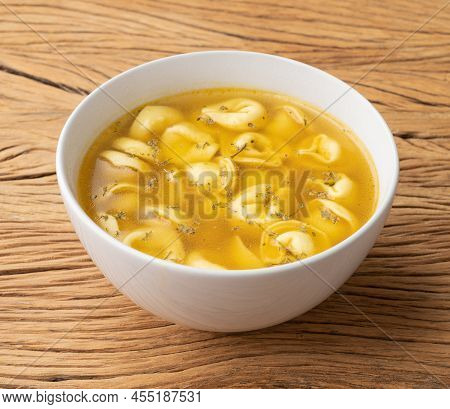 Cappelletti Or Tortellini Brodo Soup In A Bowl Over Wooden Table.