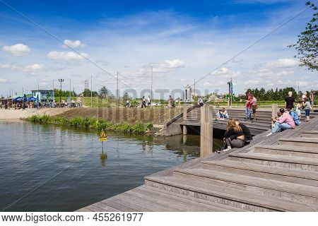 Harderwijk, Netherlands - May 22, 2022: People Sitting On The Wooden Steps At The Lake In Harderwijk