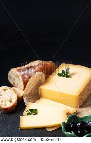 Food Concept Organic French Comté Cheese With French Bread Baquette On Black Slate Stone Board With 