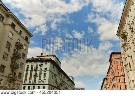 Low Angle View Of Residential Modern Buildinds With Balconies, Windows And Drainpipe. Blue Sky With 