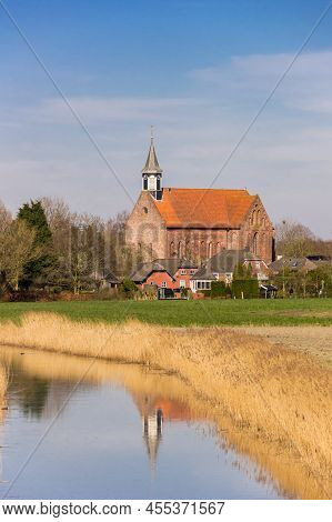 Historic Stefanus Church With Reflection In The River In Holwierde, Netherlands