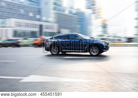 Car Bmw X4 G02 Moving On The Street. Suv Vehicle Driving Along Wet Slippery Street In City With Blur