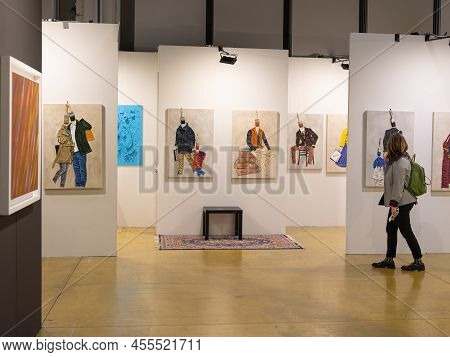 Parma, Italy - March 2022: Woman Walking And Admiring Paintings In A Modern Art Gallery.