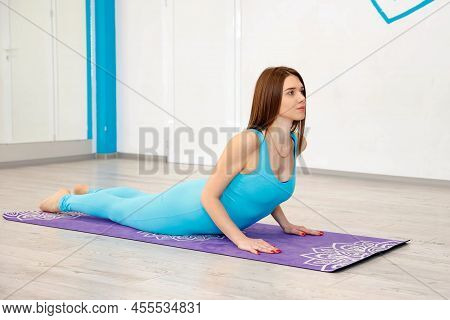 Caucasian Sportswoman Lying On Fitness Mat While Practicing Yoga In Room. Woman Practicing Yoga. Wom