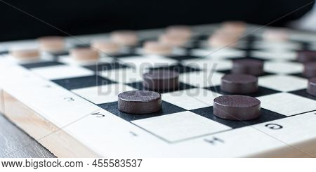 A Board With Checkers. Dark Checkers On The Board. Game For Two Persons. Intelectual Game.