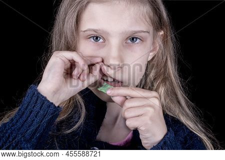 Snus. Tobacco In Bags. A Female Child Uses Nicotine. Close-up.