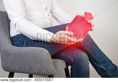 A Male Office Worker Holds A Heating Pad With Hot Water Near The Knee Joint. Treatment Of Knee Pain