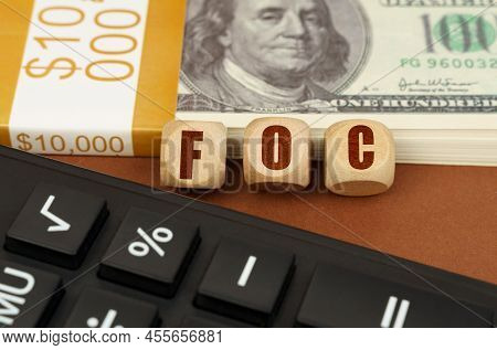 Business Concept. On The Table Are Dollars, A Calculator And Cubes With The Inscription - Foc