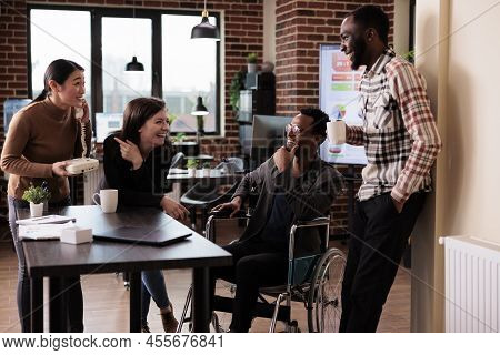 African American Man With Chronic Disability Laughing With Colleagues, Working In Disability Friendl
