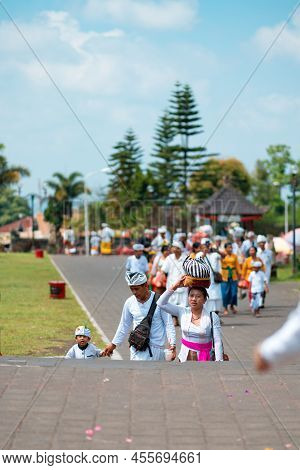 26.12.2018, Bali, Indonesia. A Traditional Balinese Family Climbs The Steps To The Temple. Vertical.