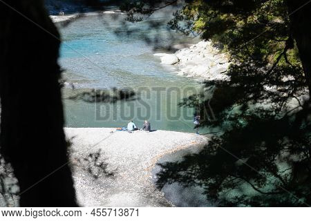 Wanaka New Zealand - April 27 2022; People With Small Burner Cooking Food Around Blue Pools On Makar